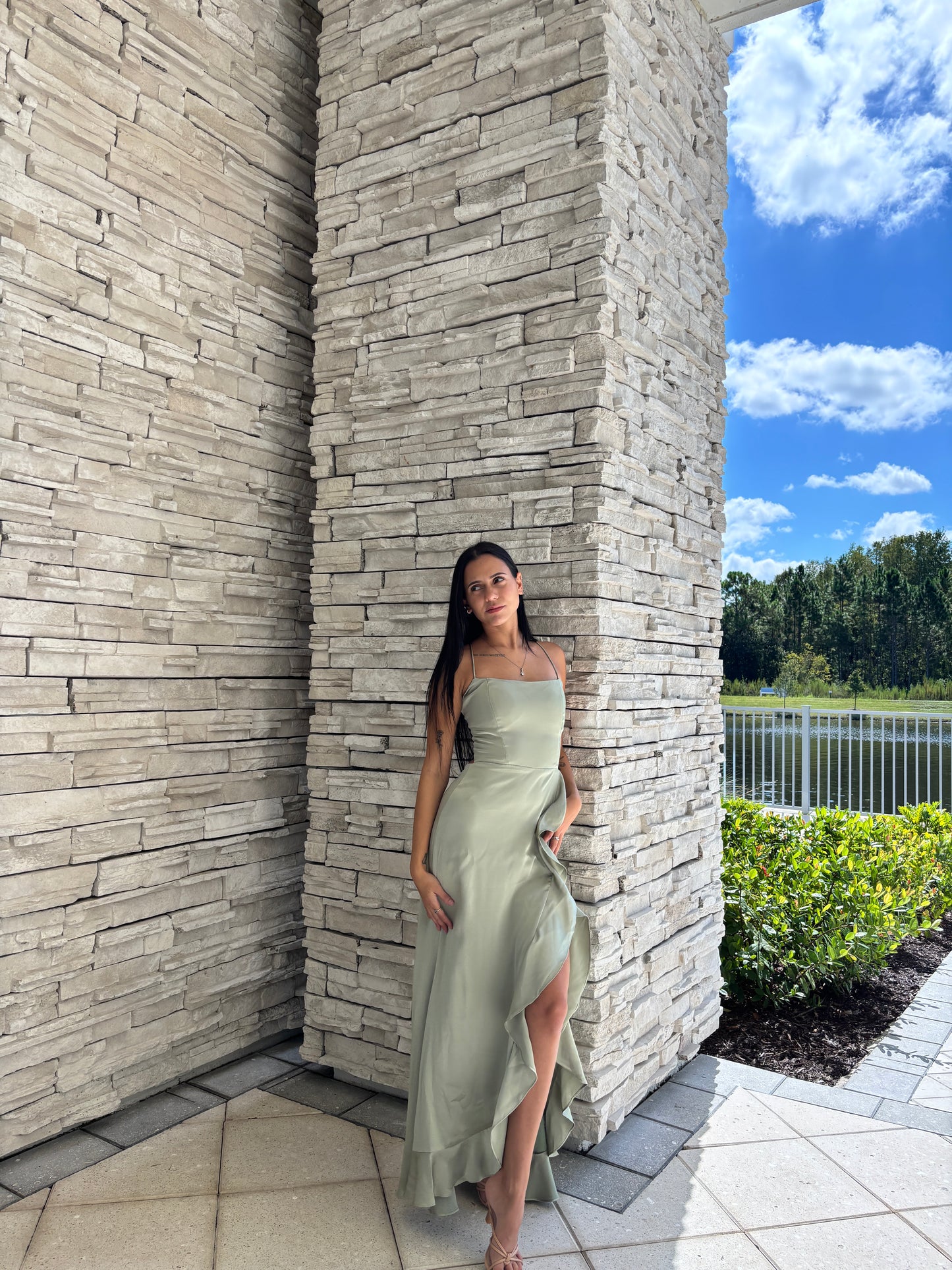 Sage satin maxi dress with a corset bodice, ruffled surplice skirt, and open back tie details, perfect for formal spring occasions