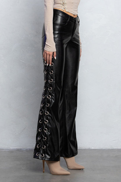 Black laced up boot cut pleather pants with grommet details and pockets, designed for an edgy yet stylish outfit.