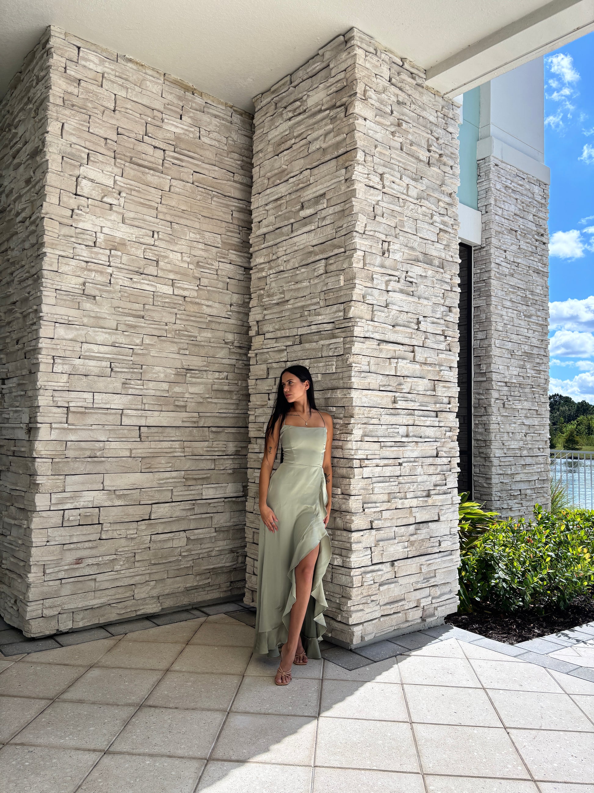 Sage satin maxi dress with a corset bodice, ruffled surplice skirt, and open back tie details, perfect for formal spring occasions