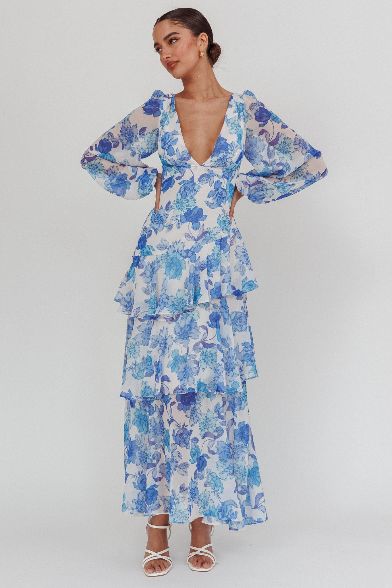 Long sleeve blue floral tiered maxi dress with deep V neckline and back tie wrap.