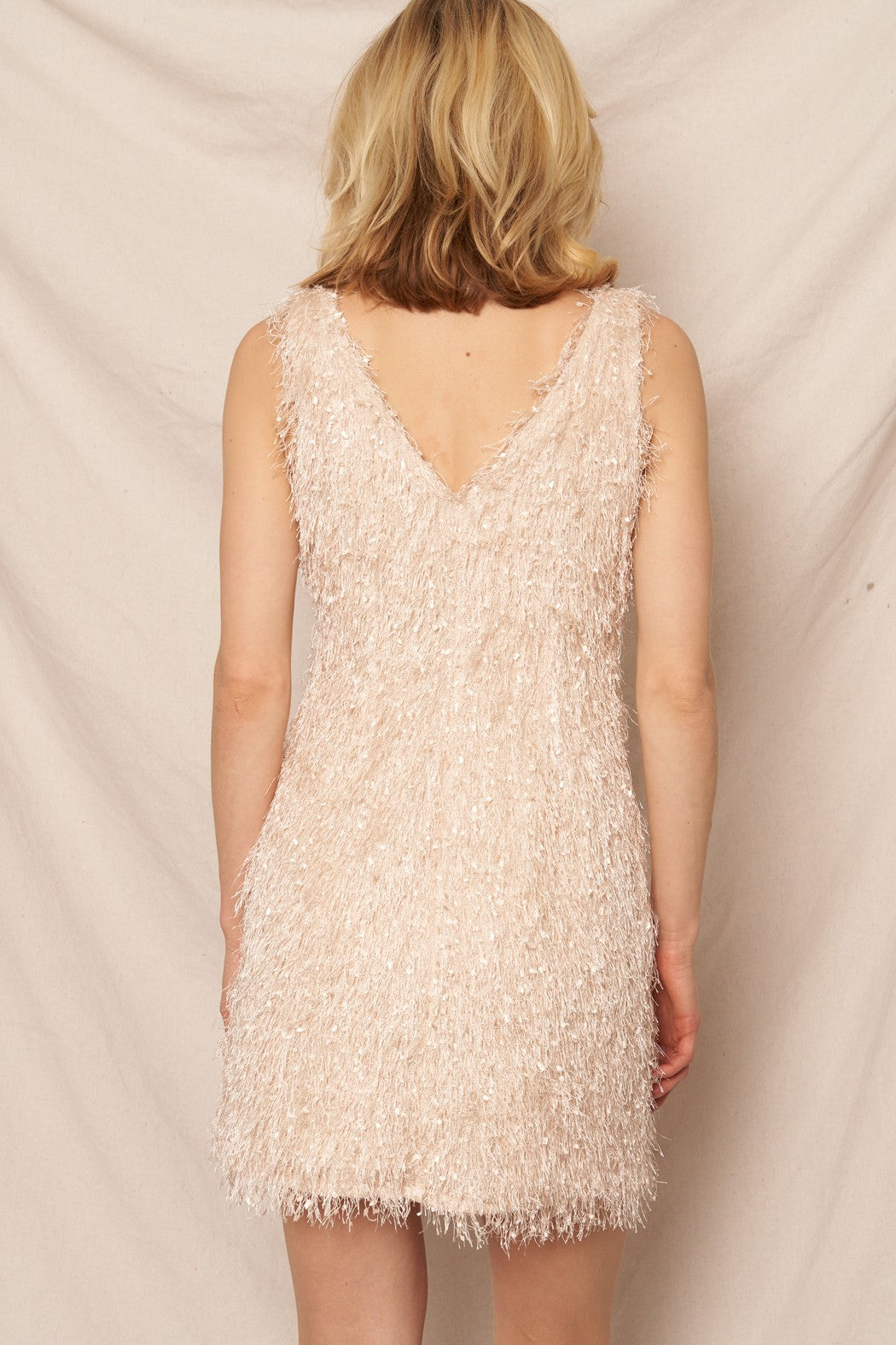 Cream sleeveless fringe mini dress with a V-neckline, perfect for New Year’s Eve and holiday celebrations.