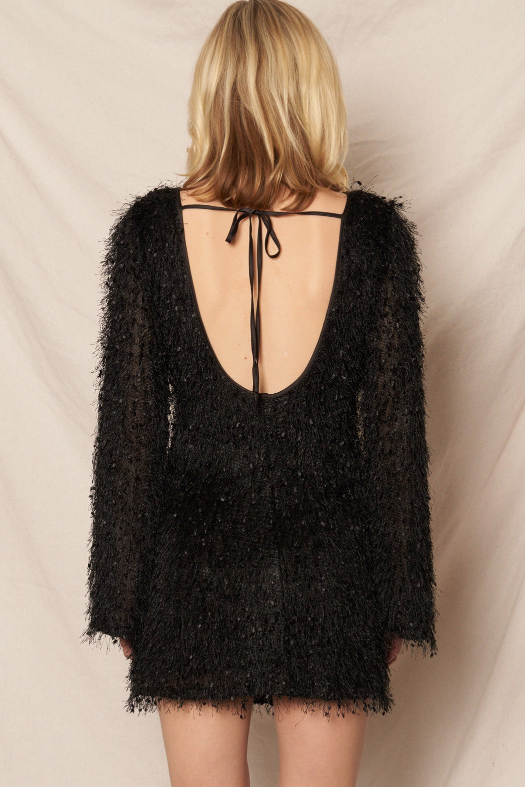 Black long sleeve mini dress with fluffy fringe details, ideal for festive events and New Year’s Eve.