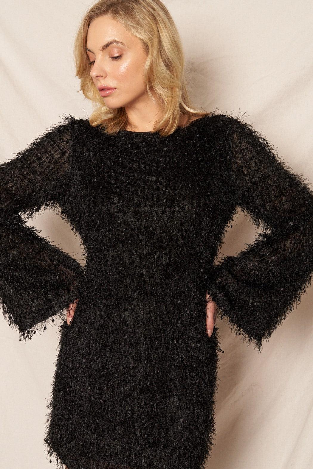 Black long sleeve mini dress with fluffy fringe details, ideal for festive events and New Year’s Eve.