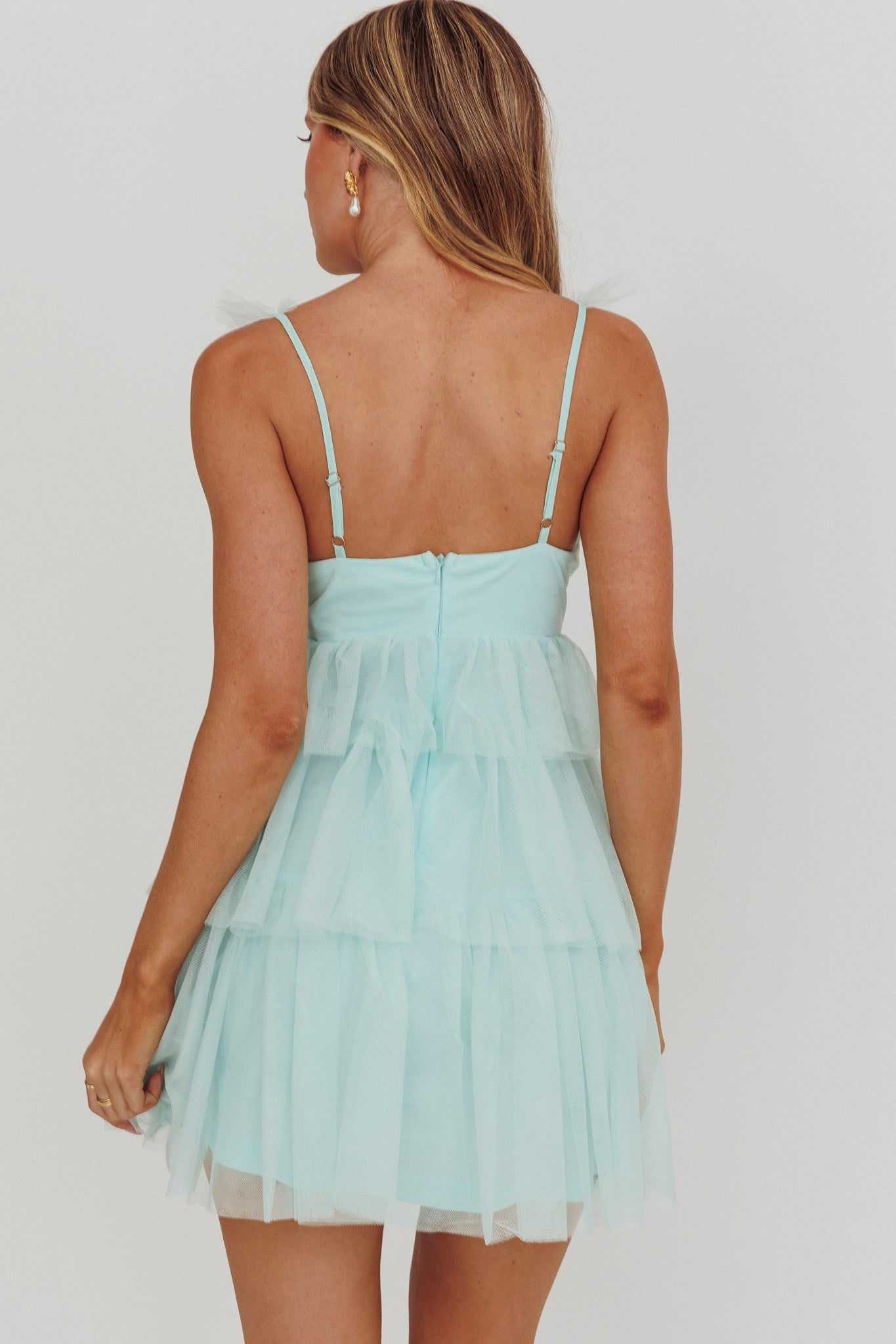 Sleeveless knit mini dress in mint with ruffle detail and tiered skirt.