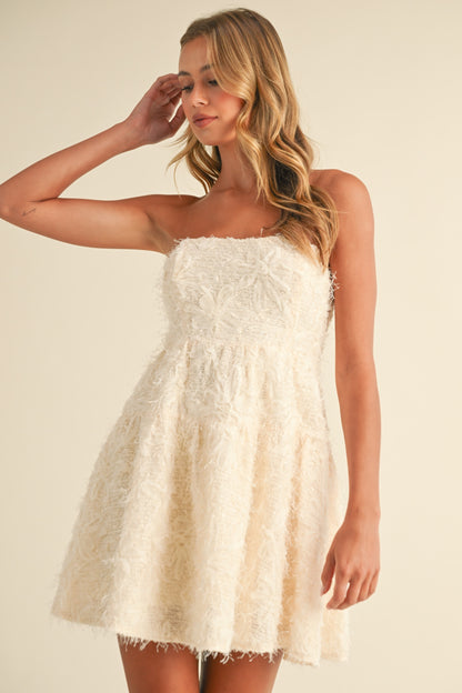 Cream strapless A-line mini dress with sequin texture, perfect for baby showers and special occasions.