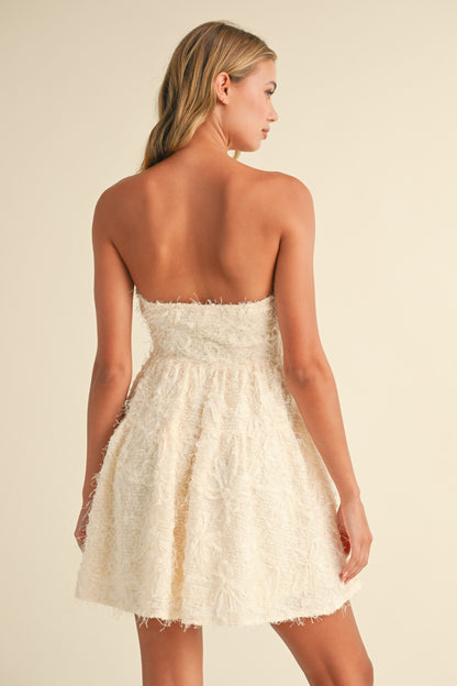 Cream strapless A-line mini dress with sequin texture, perfect for baby showers and special occasions.