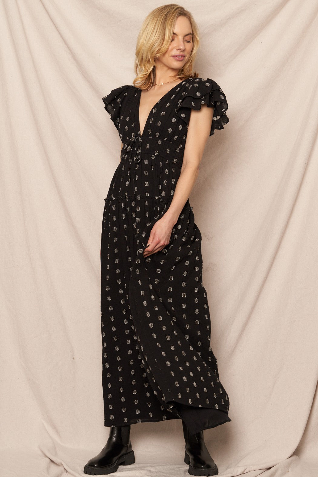 Black polka dot maxi dress with a V-neckline and ruffle sleeves, perfect for casual Christmas gatherings.