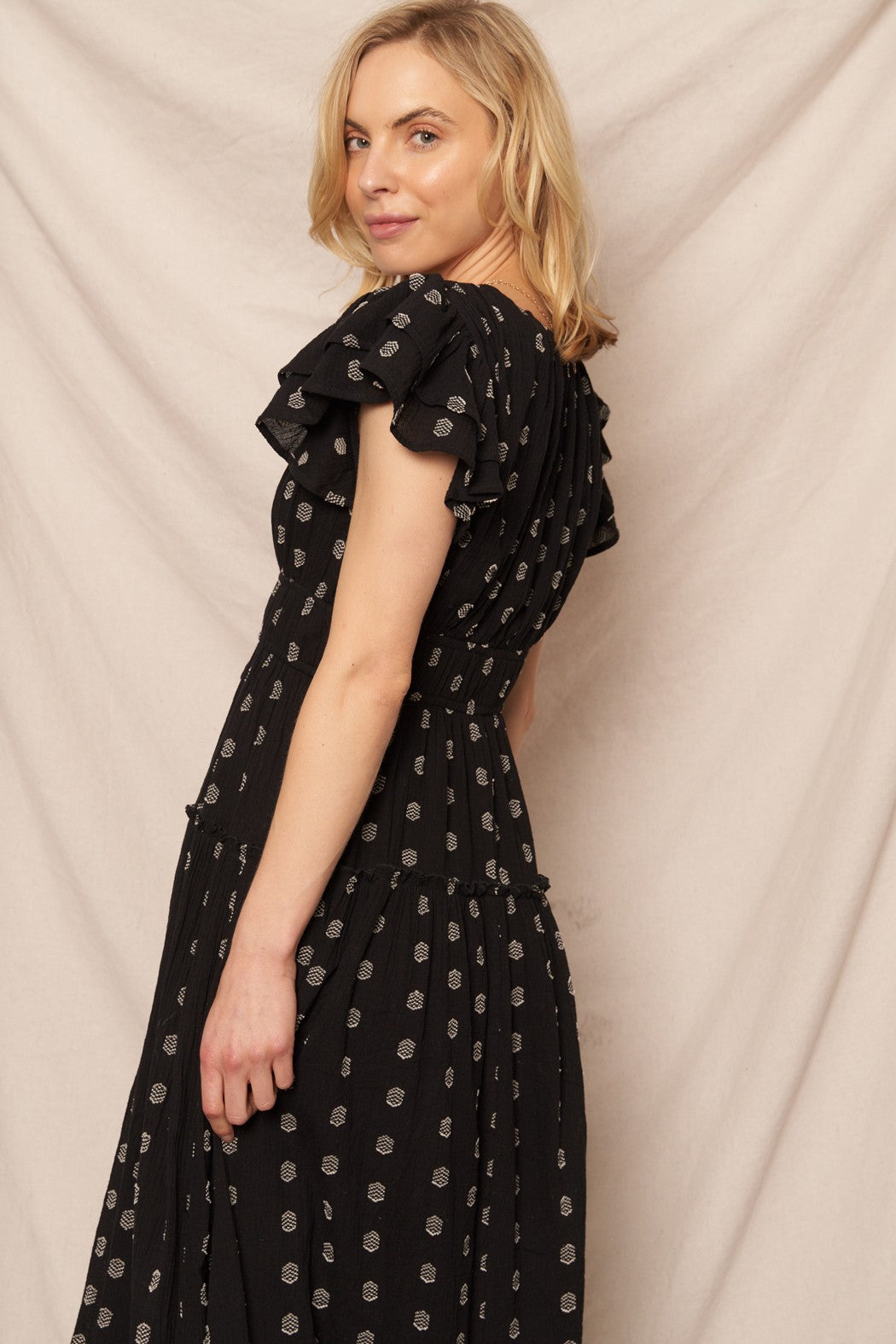 Black polka dot maxi dress with a V-neckline and ruffle sleeves, perfect for casual Christmas gatherings.