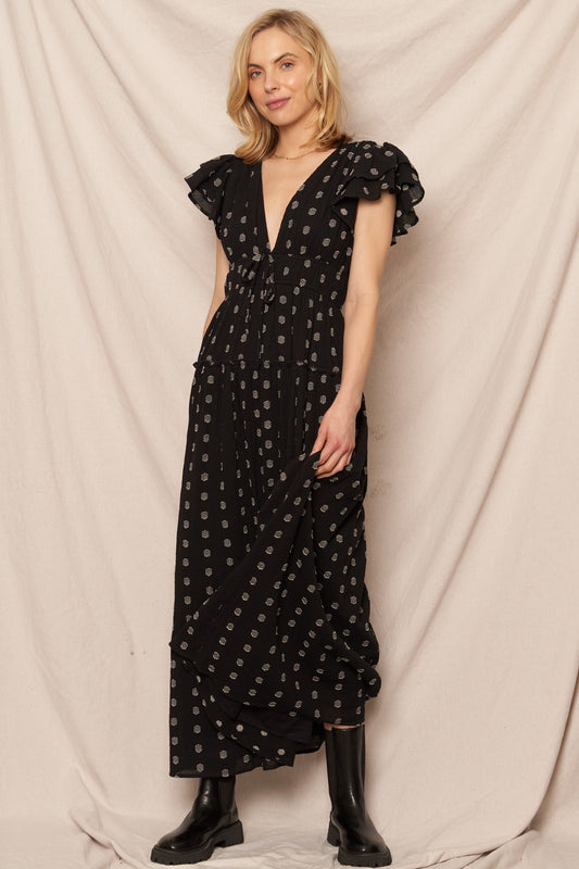 Black polka dot maxi dress with a V-neckline and ruffle sleeves, perfect for casual Christmas gatherings.