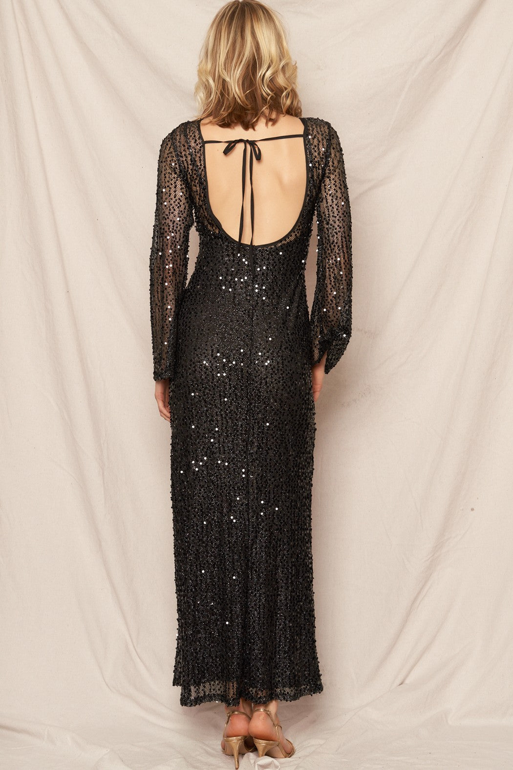 Black sequin maxi dress with elegant bell sleeves, perfect for New Year's celebrations and glamorous events.