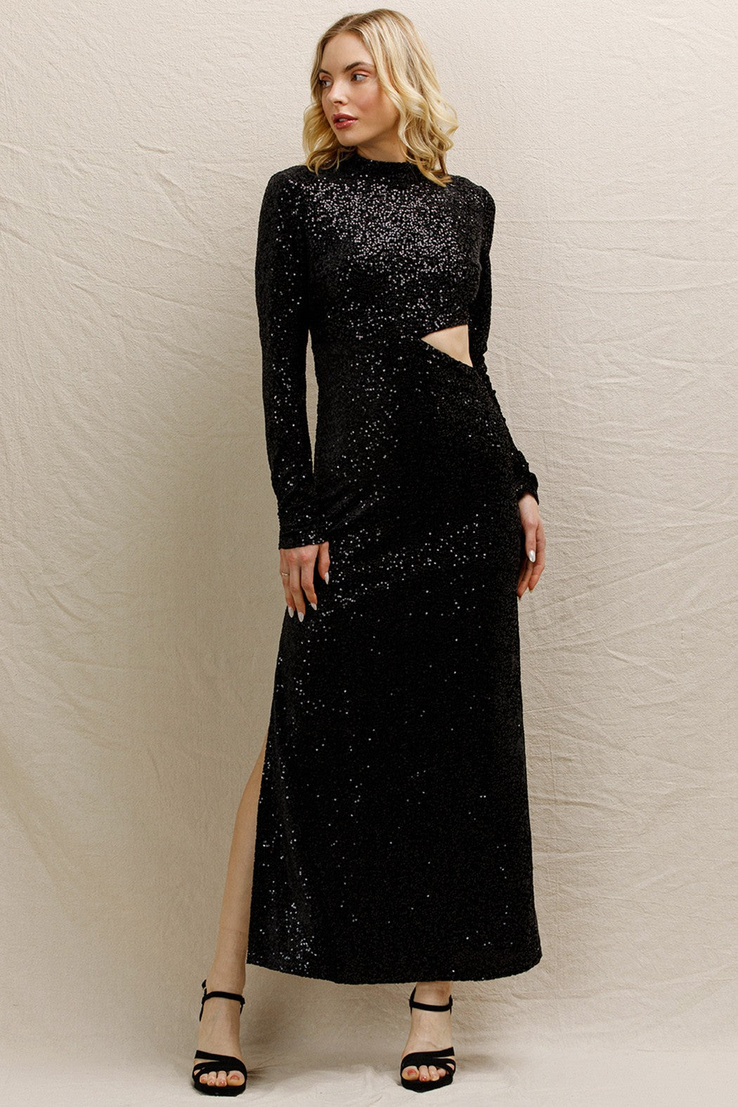 Black sequin maxi dress with a mock neck and side cut-outs, perfect for holiday parties and festive events.