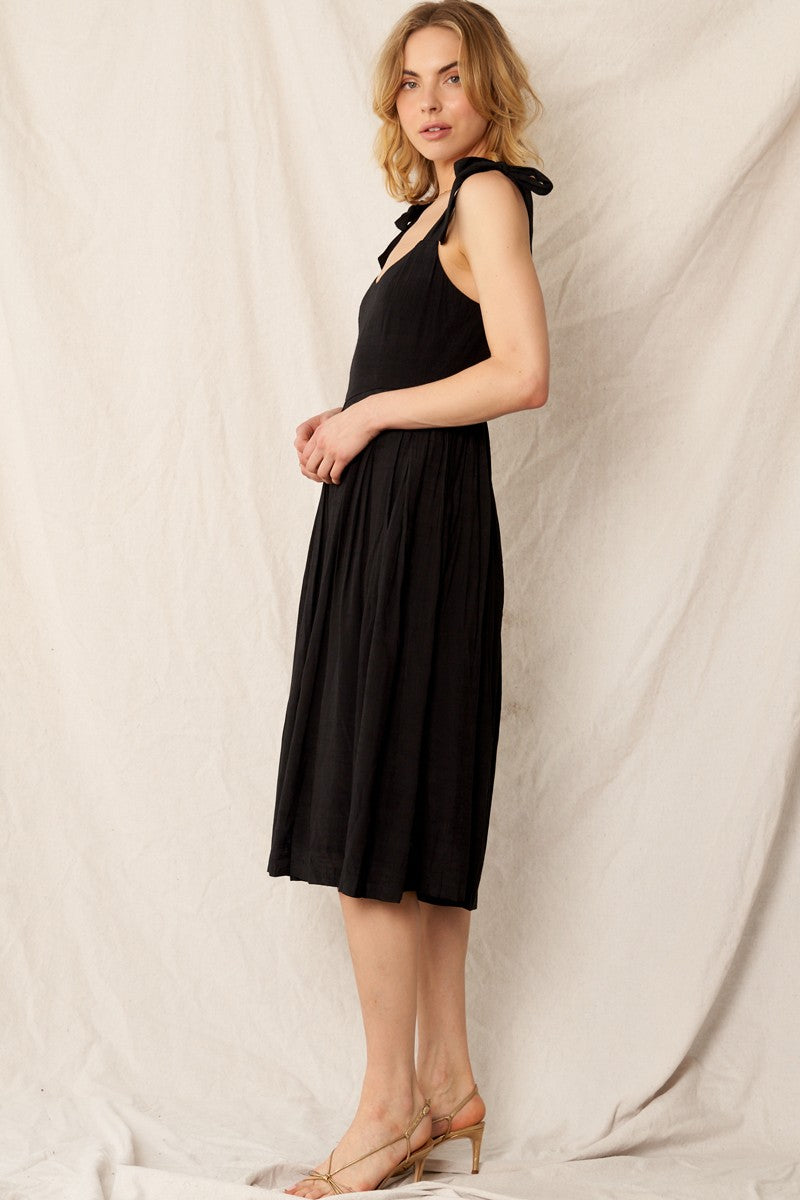 Elegant black jumpsuit with shoulder tie straps, pleated wide-leg pants, and hidden back zipper closure. Perfect for holiday outfits and formal occasions