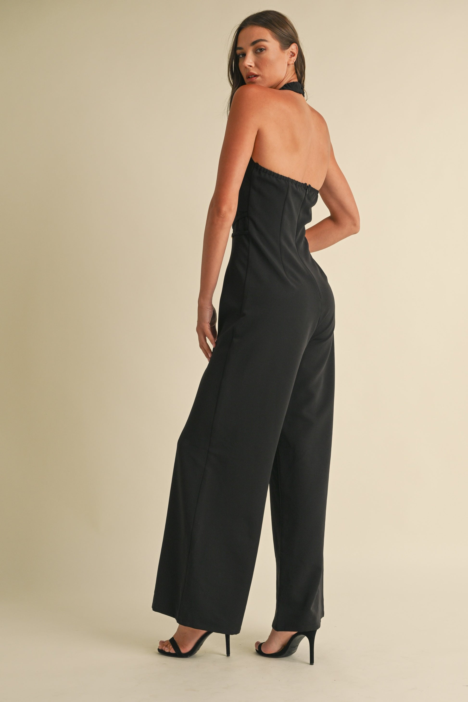 Noir Luxe Halter Jumpsuit in black with a wide-leg fit, gold trim detail, and a back zipper closure.