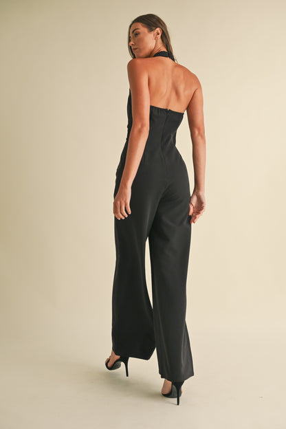 Noir Luxe Halter Jumpsuit in black with a wide-leg fit, gold trim detail, and a back zipper closure.