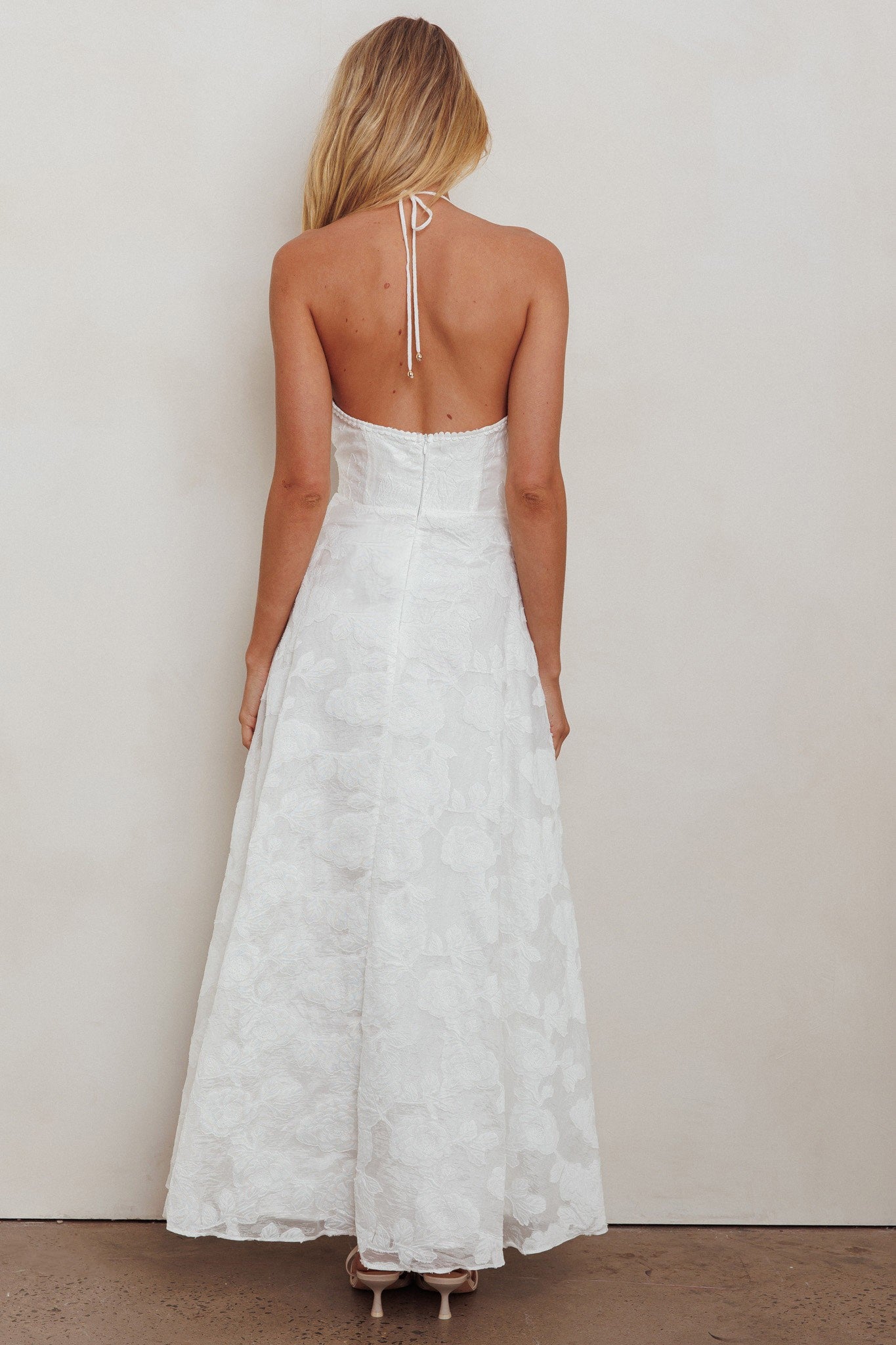 The Petal Whisper Bridal Dress, a strapless halterneck dress with floral lace details and an open back, in elegant white.