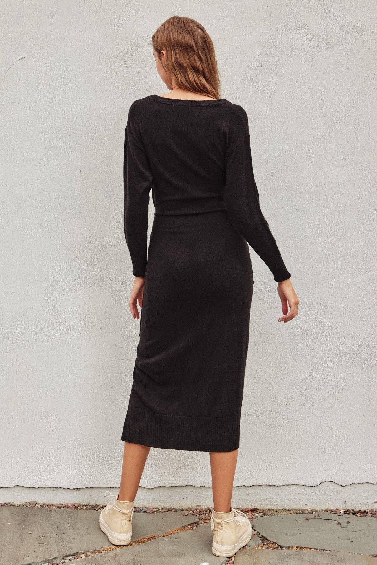 Black pull-over knit midi dress with a wrapping top layer, buckle fastening, and snap button neckline, perfect for winter casual wear and brunch.