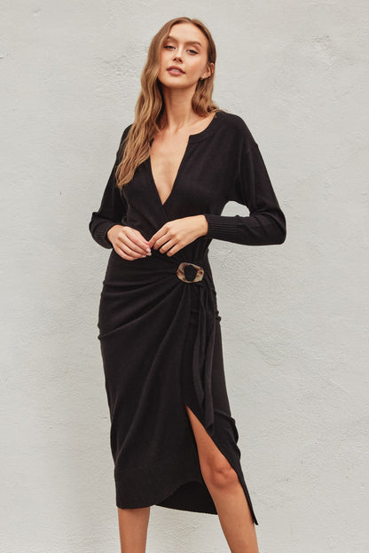 Black pull-over knit midi dress with a wrapping top layer, buckle fastening, and snap button neckline, perfect for winter casual wear and brunch.