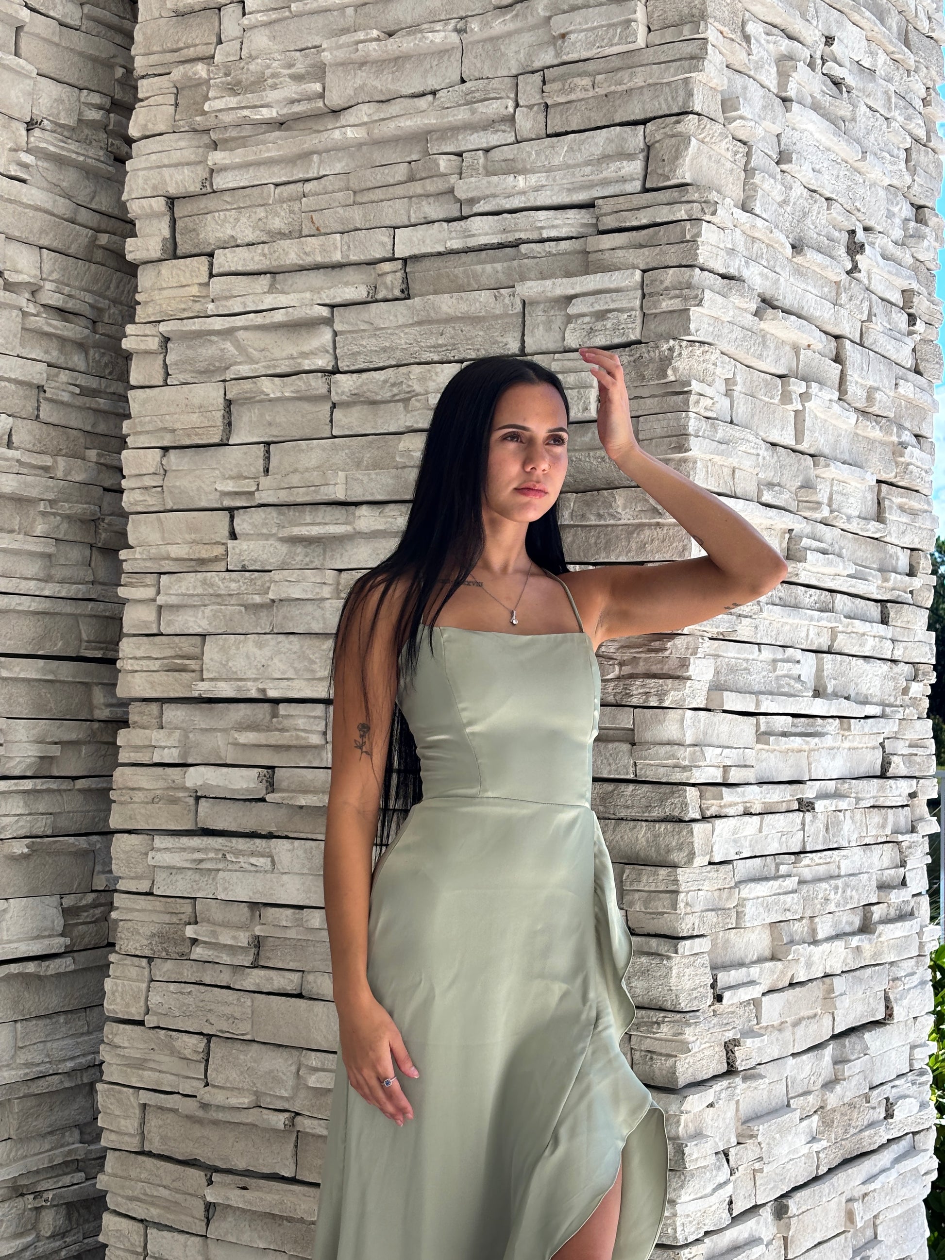 Sage satin maxi dress with a corset bodice, ruffled surplice skirt, and open back tie details, perfect for formal spring occasions