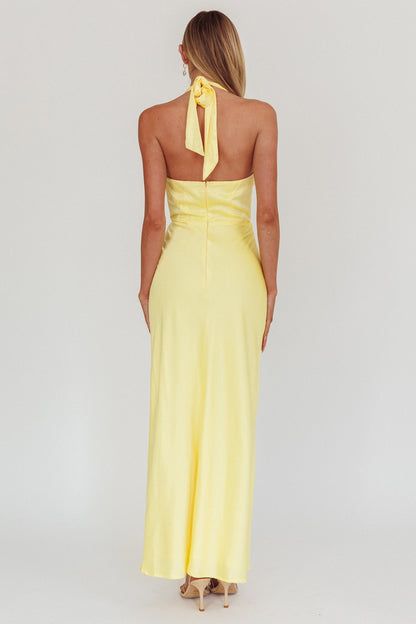 Halter neck front twist maxi dress in lemon with open back and bow tie.