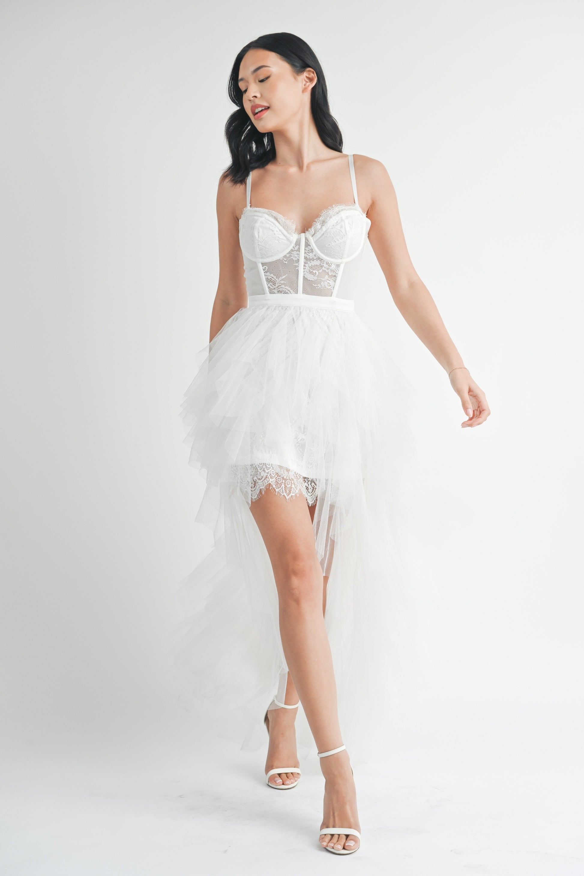 White strapless tulle maxi dress with a structured lace bodice, side slit, and ruffled mesh outer layer.